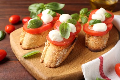 Photo of Tasty sandwiches with mozzarella cheese, tomatoes and basil on wooden table, closeup