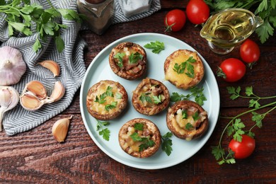 Photo of Tasty stuffed mushrooms and ingredients on wooden table, flat lay