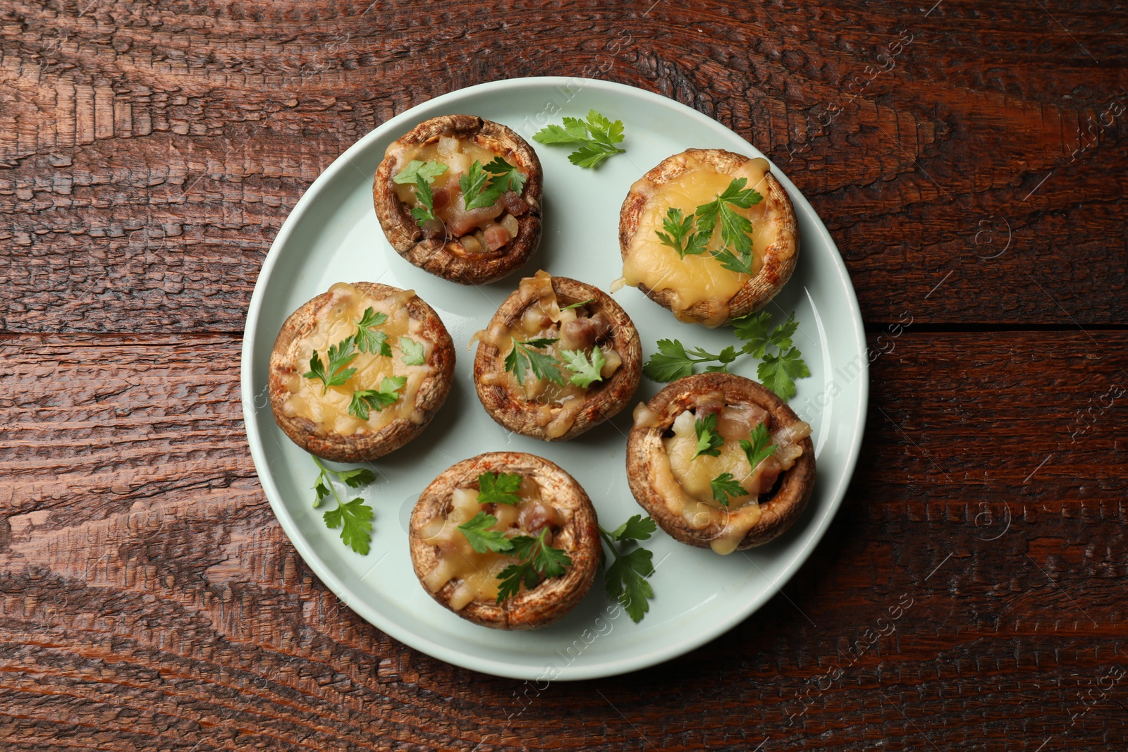 Tasty stuffed mushrooms on wooden table, top view Photo of Tasty stuffed mushrooms on wooden table, top view