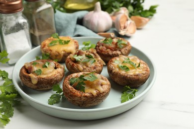 Photo of Tasty stuffed mushrooms and spices on white marble table, closeup