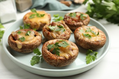 Photo of Tasty stuffed mushrooms and spices on white marble table, closeup
