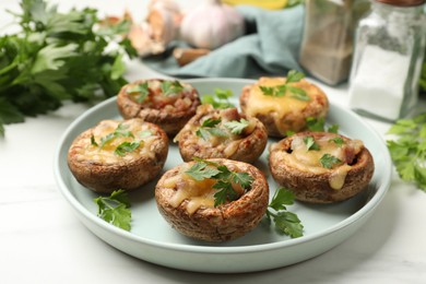 Photo of Tasty stuffed mushrooms and spices on white marble table, closeup
