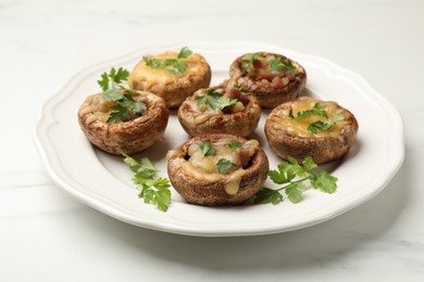Photo of Tasty stuffed mushrooms on white marble table, closeup