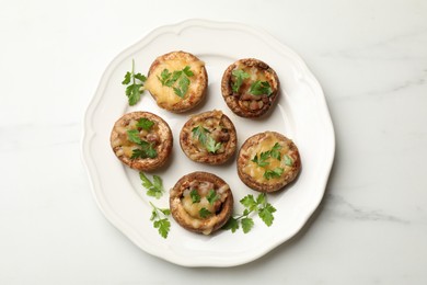 Photo of Tasty stuffed mushrooms on white marble table, top view