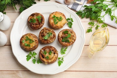 Photo of Tasty stuffed mushrooms served on wooden table, flat lay