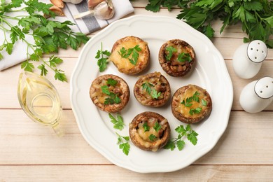 Photo of Tasty stuffed mushrooms served on wooden table, flat lay