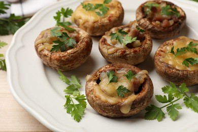 Photo of Tasty stuffed mushrooms served on table, closeup