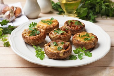 Photo of Tasty stuffed mushrooms served on wooden table, closeup