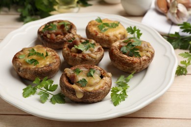 Photo of Tasty stuffed mushrooms served on wooden table, closeup