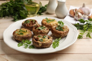 Photo of Tasty stuffed mushrooms served on wooden table, closeup