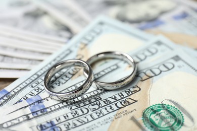 Photo of Silver wedding rings and dollar banknotes, closeup