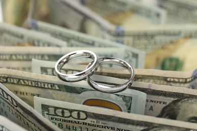Photo of Silver wedding rings and dollar banknotes, closeup