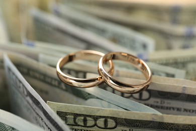 Photo of Gold wedding rings and dollar banknotes, closeup
