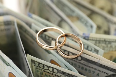 Photo of Gold wedding rings and dollar banknotes, closeup
