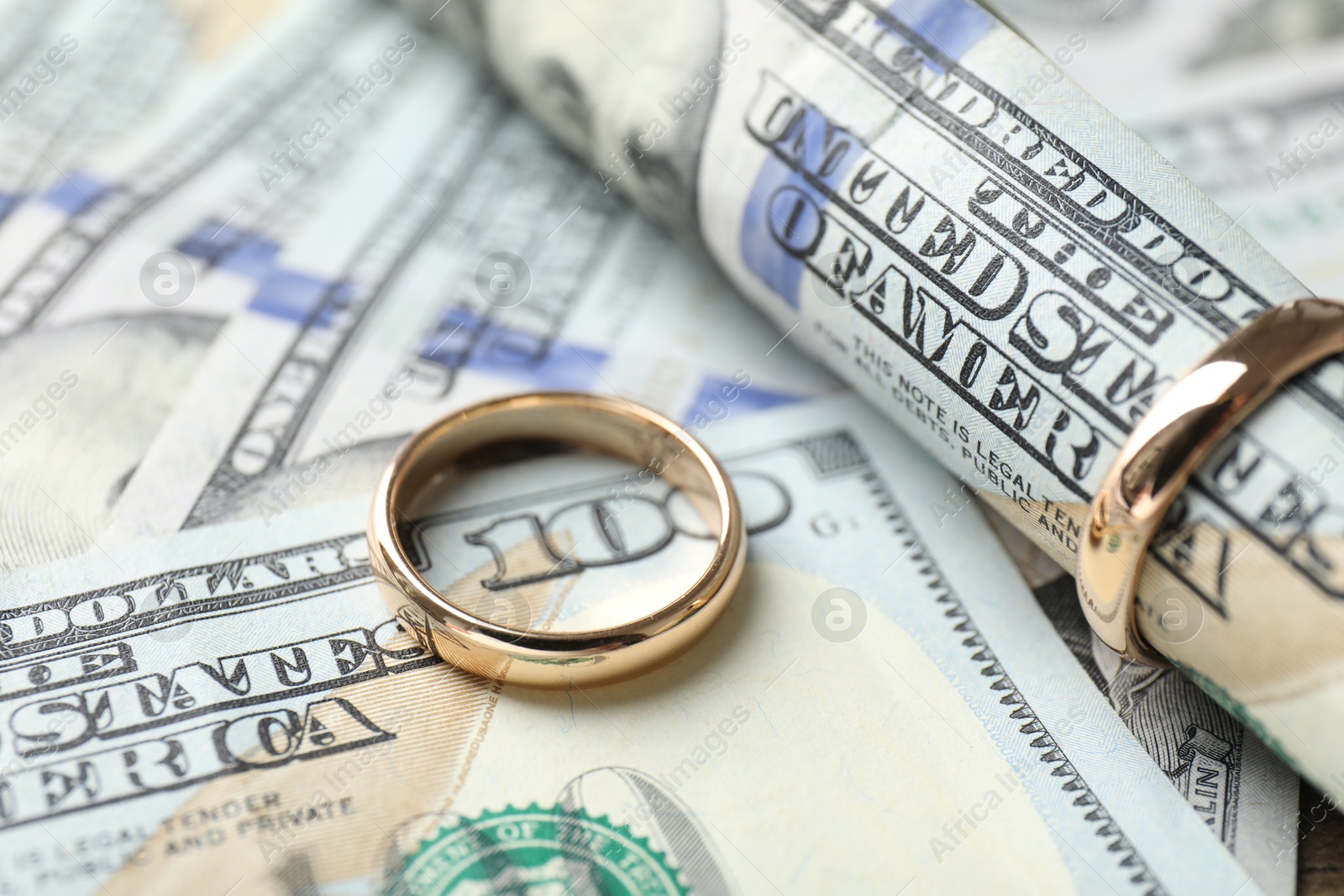 Photo of Gold wedding rings and dollar banknotes, closeup