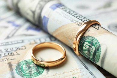 Photo of Gold wedding rings and dollar banknotes, closeup