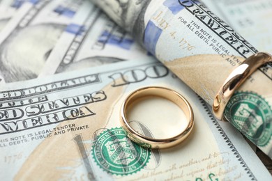 Photo of Gold wedding rings and dollar banknotes, closeup