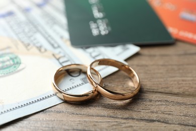 Photo of Gold wedding rings and credit cards on wooden table, closeup
