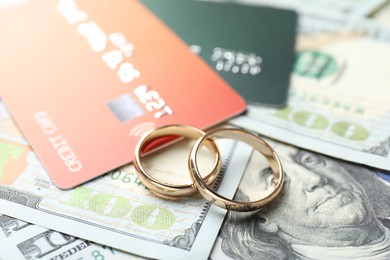 Photo of Gold wedding rings, dollar banknotes and credit cards, closeup