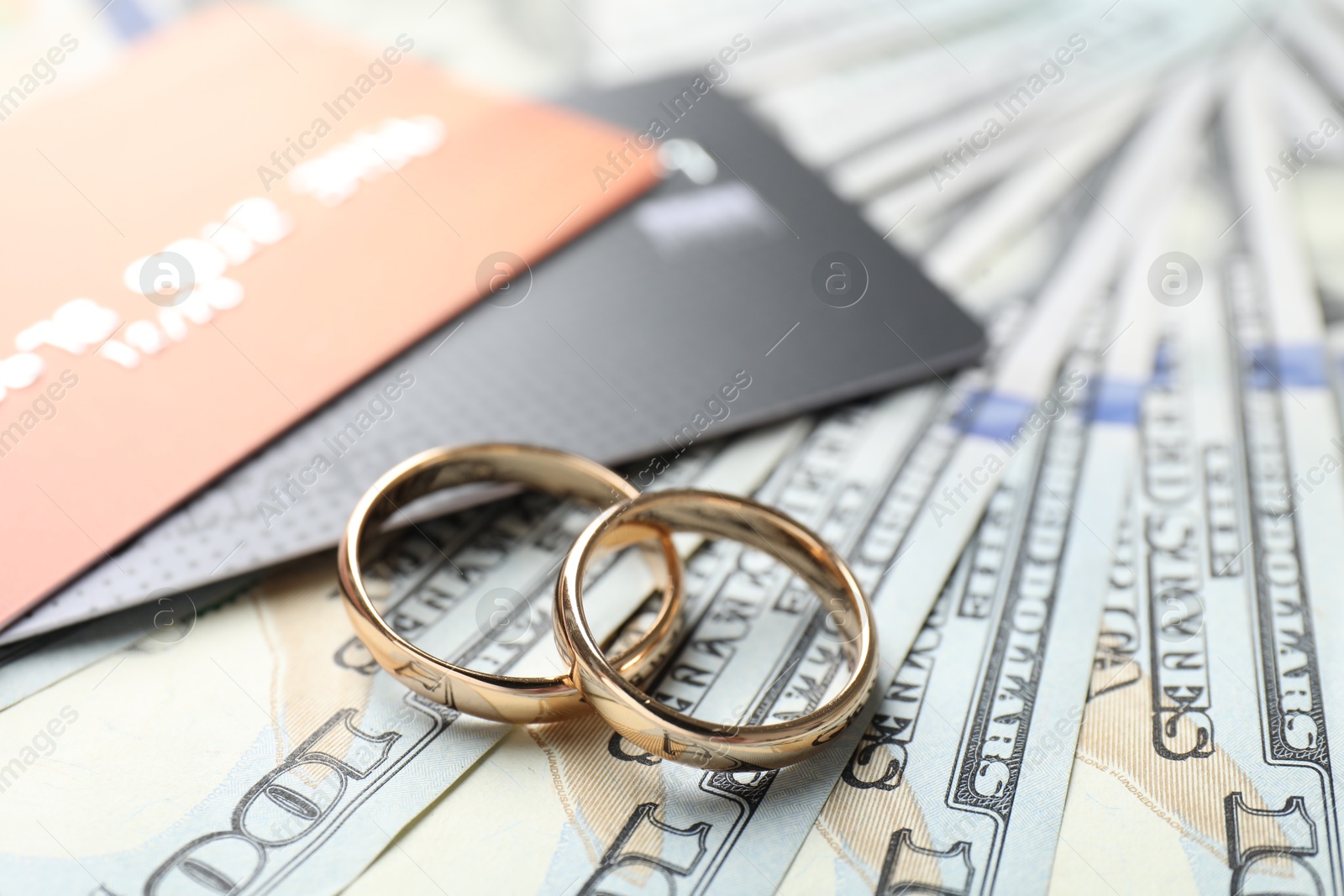 Photo of Gold wedding rings, dollar banknotes and credit cards, closeup
