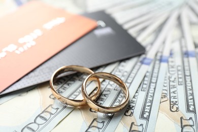 Photo of Gold wedding rings, dollar banknotes and credit cards, closeup