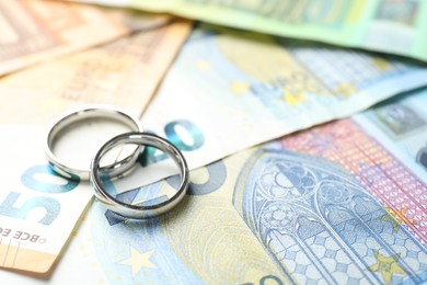 Photo of Silver wedding rings and euro banknotes, closeup. Space for text