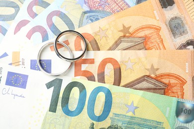 Photo of Silver wedding rings and euro banknotes, flat lay