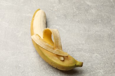 Photo of Banana with heart made of peel on grey table, closeup