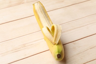 Photo of Banana with heart made of peel on wooden table, above view