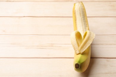 Photo of Banana with heart made of peel on wooden table, above view. Space for text