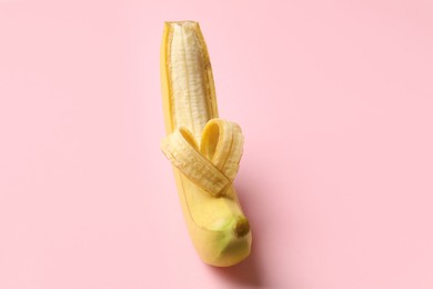 Photo of Banana with heart made of peel on pink background, closeup