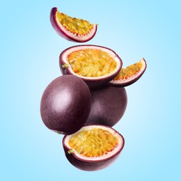 Image of Delicious ripe passion fruits falling on light blue background