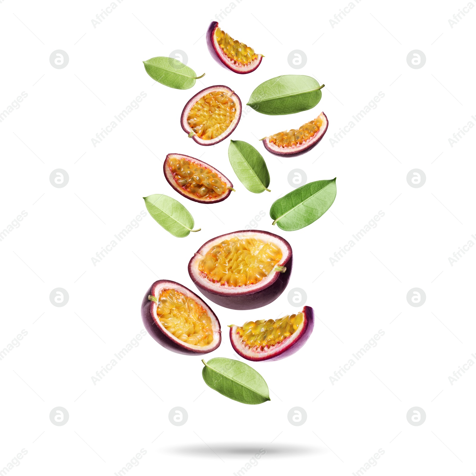Delicious cut passion fruits and green leaves falling on white background Image of Delicious cut passion fruits and green leaves falling on white background