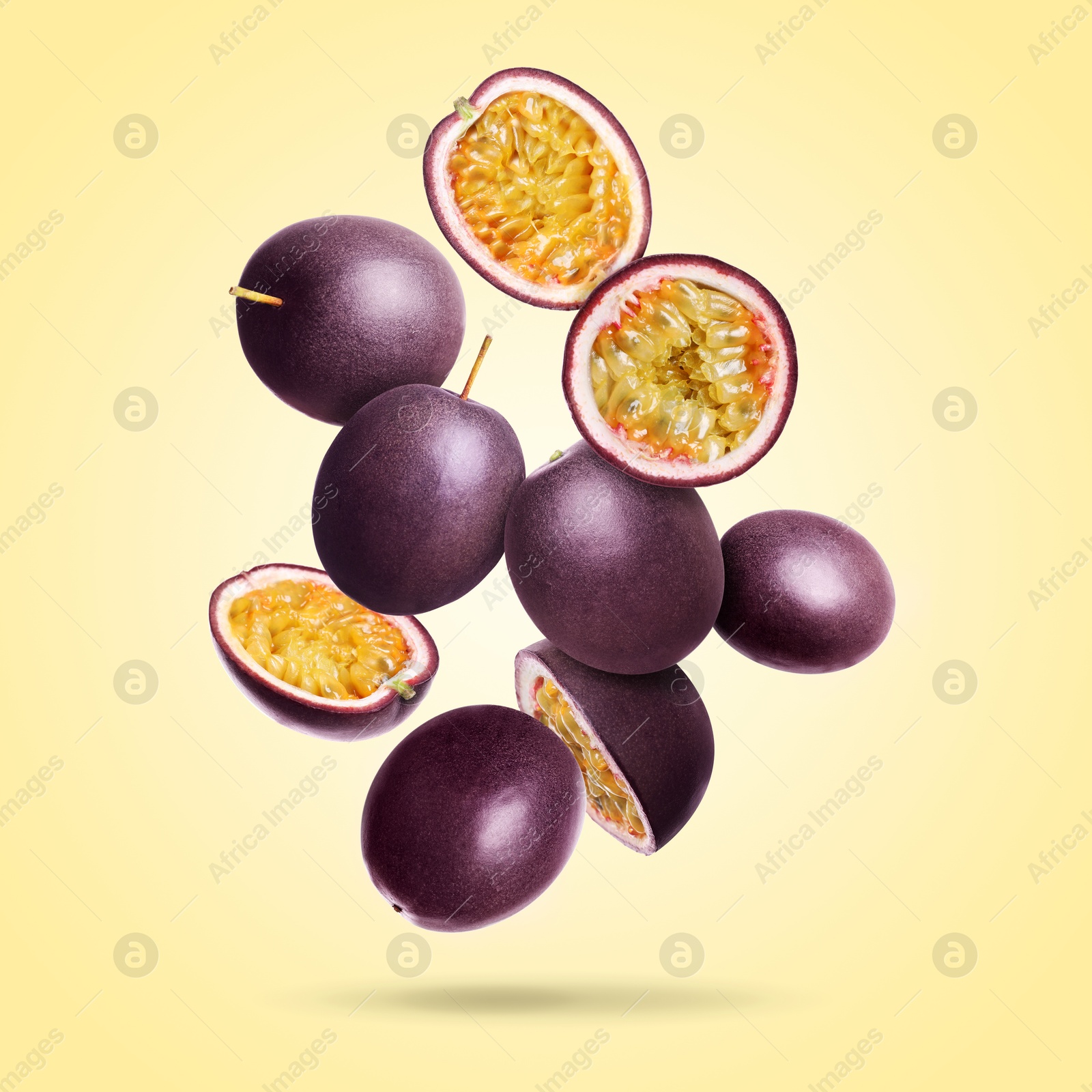 Delicious ripe passion fruits falling on pale yellow gradient background Image of Delicious ripe passion fruits falling on pale yellow gradient background