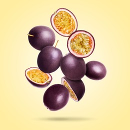 Image of Delicious ripe passion fruits falling on pale yellow gradient background