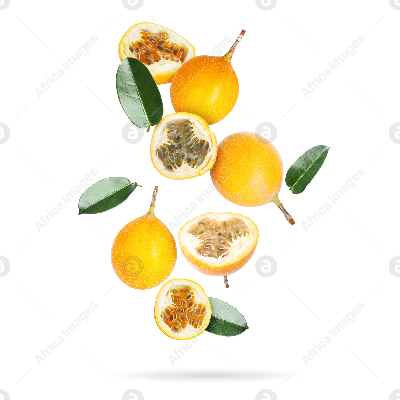Delicious ripe passion fruits and green leaves falling on white background Image of Delicious ripe passion fruits and green leaves falling on white background