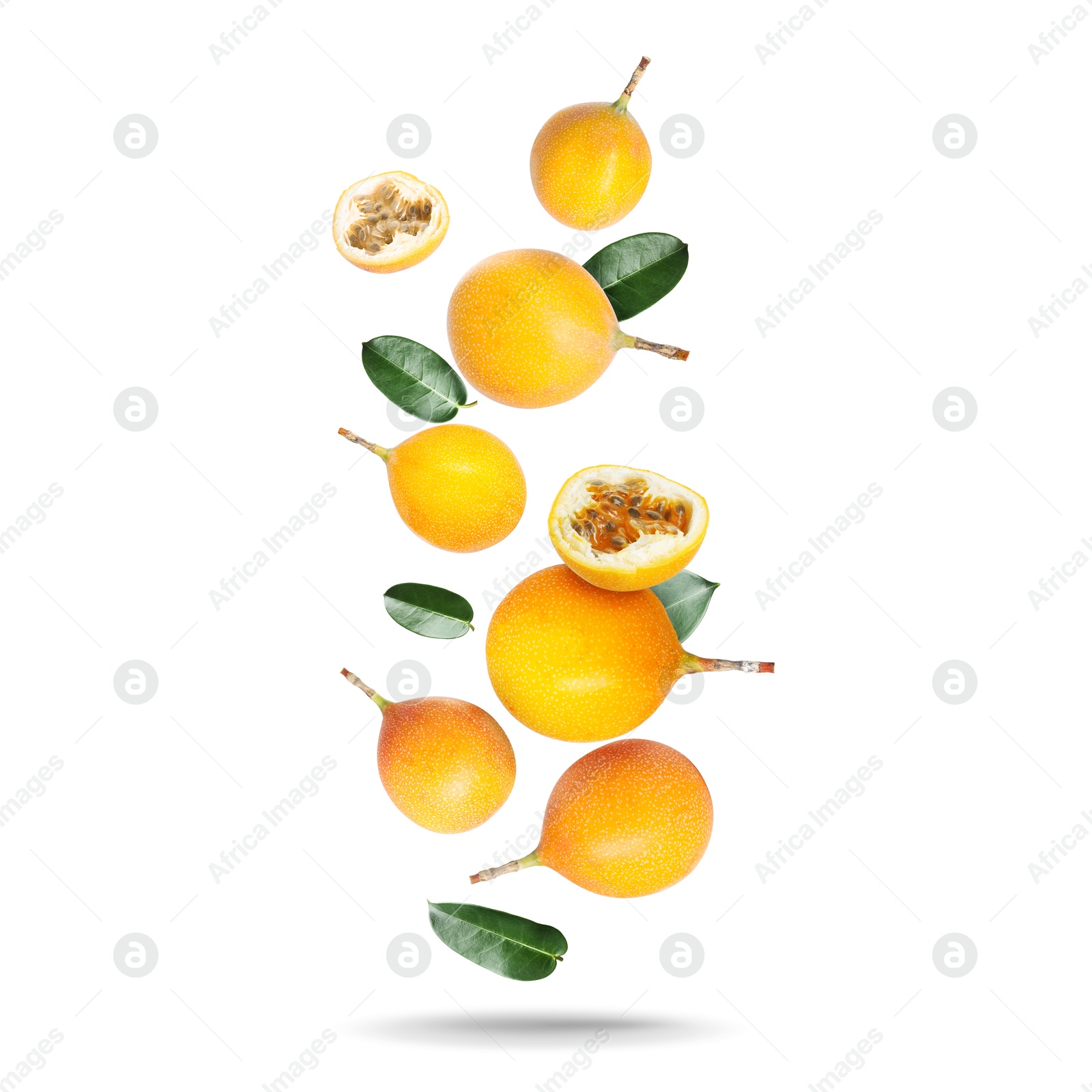 Delicious ripe passion fruits and green leaves falling on white background Image of Delicious ripe passion fruits and green leaves falling on white background