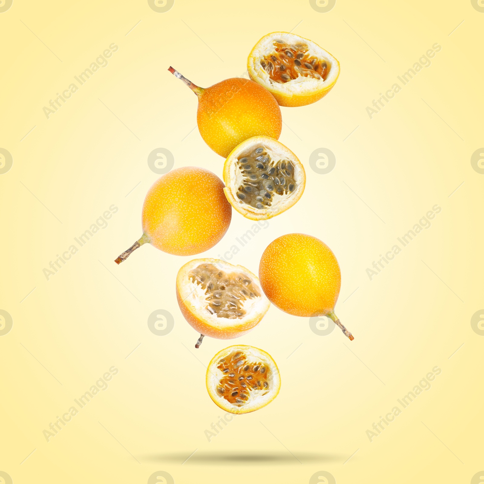 Delicious ripe passion fruits falling on pale yellow gradient background Image of Delicious ripe passion fruits falling on pale yellow gradient background