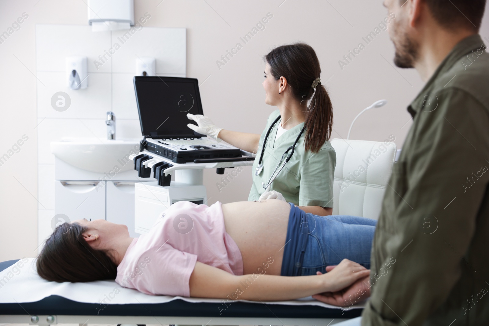 Photo of Woman and her husband attending prenatal ultrasound examination in clinic