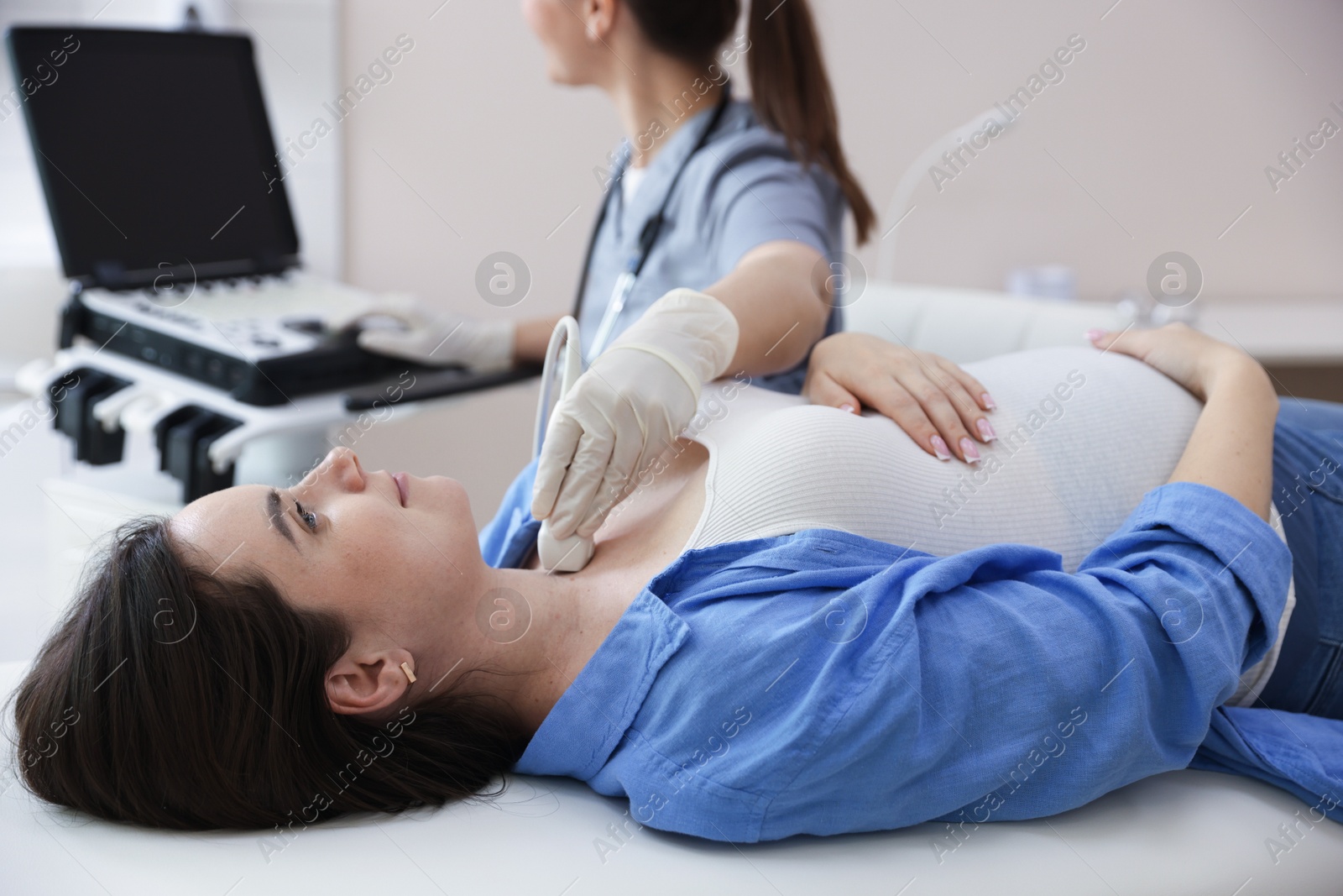 Sonographer conducting ultrasound examination of woman's thyroid gland in clinic, closeup Photo of Sonographer conducting ultrasound examination of woman's thyroid gland in clinic, closeup