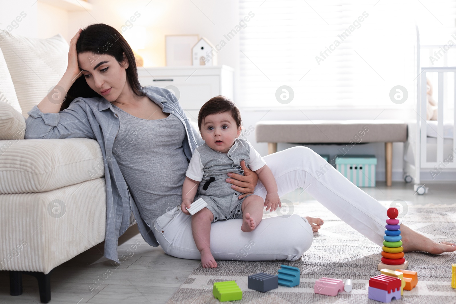 Woman suffering from postpartum depression with her little baby at home. Space for text Photo of Woman suffering from postpartum depression with her little baby at home. Space for text