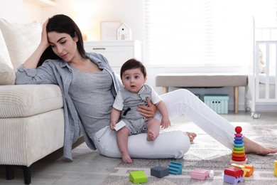 Photo of Woman suffering from postpartum depression with her little baby at home. Space for text