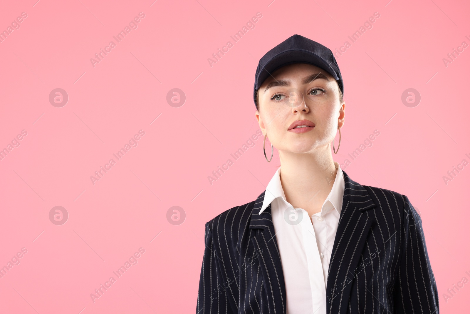 Beautiful woman in stylish baseball hat on pink background. Space for text Photo of Beautiful woman in stylish baseball hat on pink background. Space for text
