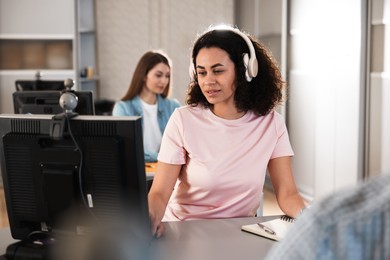 Photo of People working at desks in library, selective focus