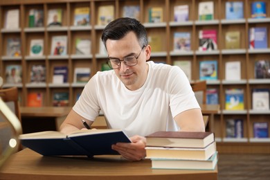 Photo of Man studying at desk in public library