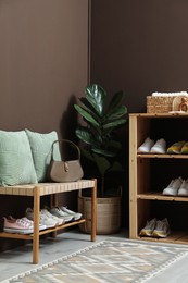 Photo of Different footwear on shelves in entryway. Shoe storage