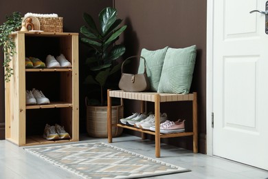 Photo of Different footwear on shelves in entryway. Shoe storage