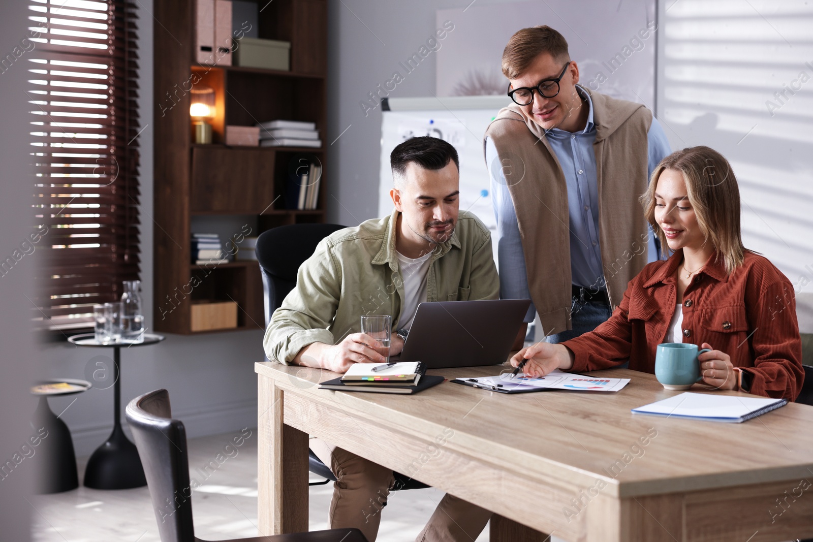 Marketing. Team of businesspeople working together at desk in office Photo of Marketing. Team of businesspeople working together at desk in office