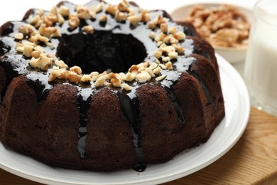 Photo of Delicious chocolate bundt cake with nuts on table, closeup