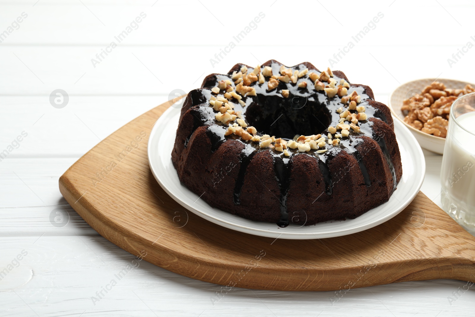 Delicious chocolate bundt cake with nuts on white wooden table, closeup Photo of Delicious chocolate bundt cake with nuts on white wooden table, closeup
